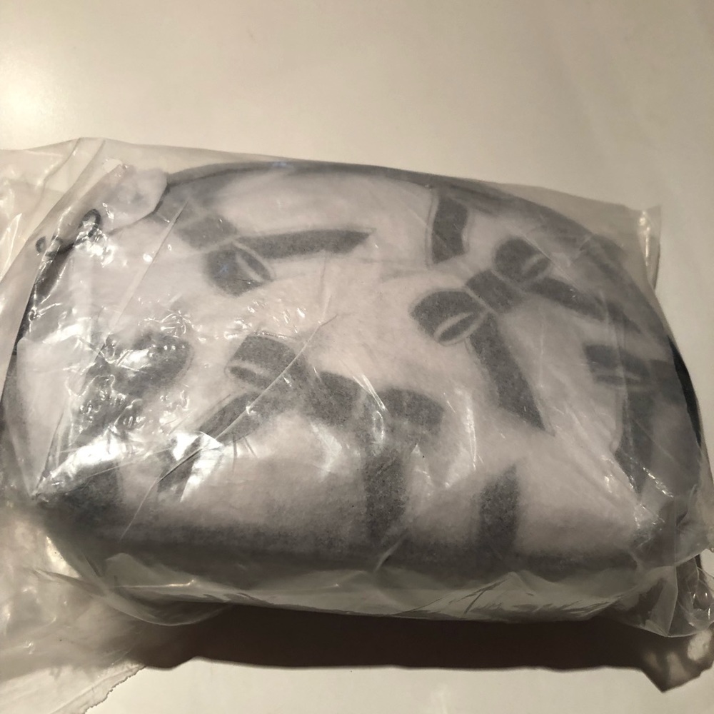 NWT in plastic Saks Fifth Avenue white PVC clutch /cosmetics bag with black bows